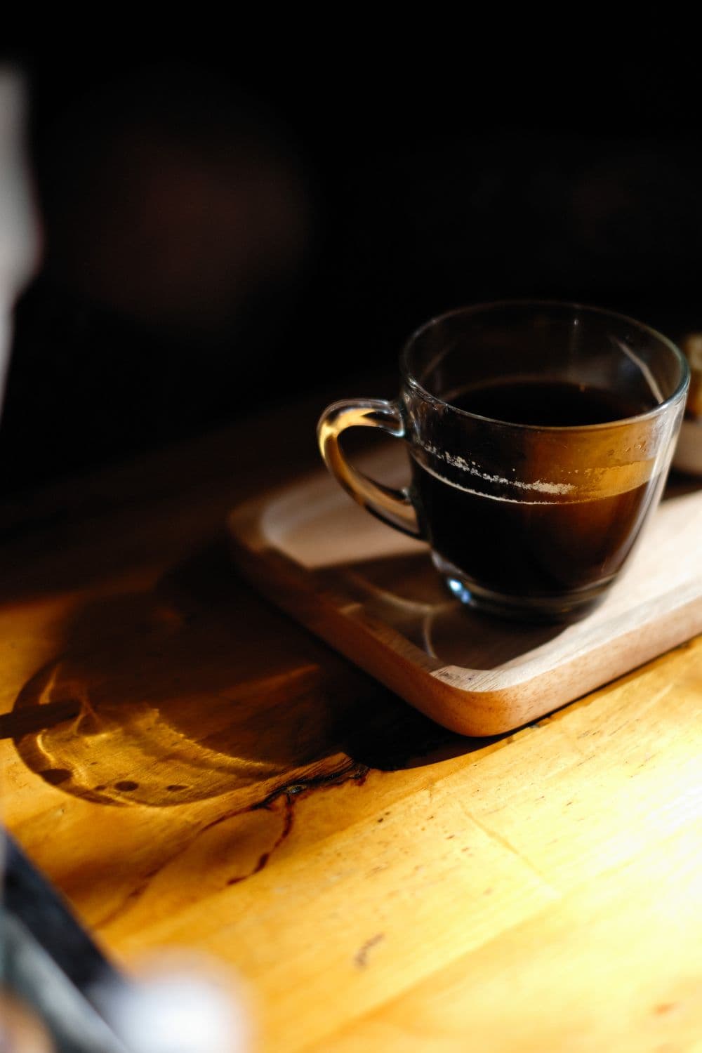 Black americano in a glass mug on wood