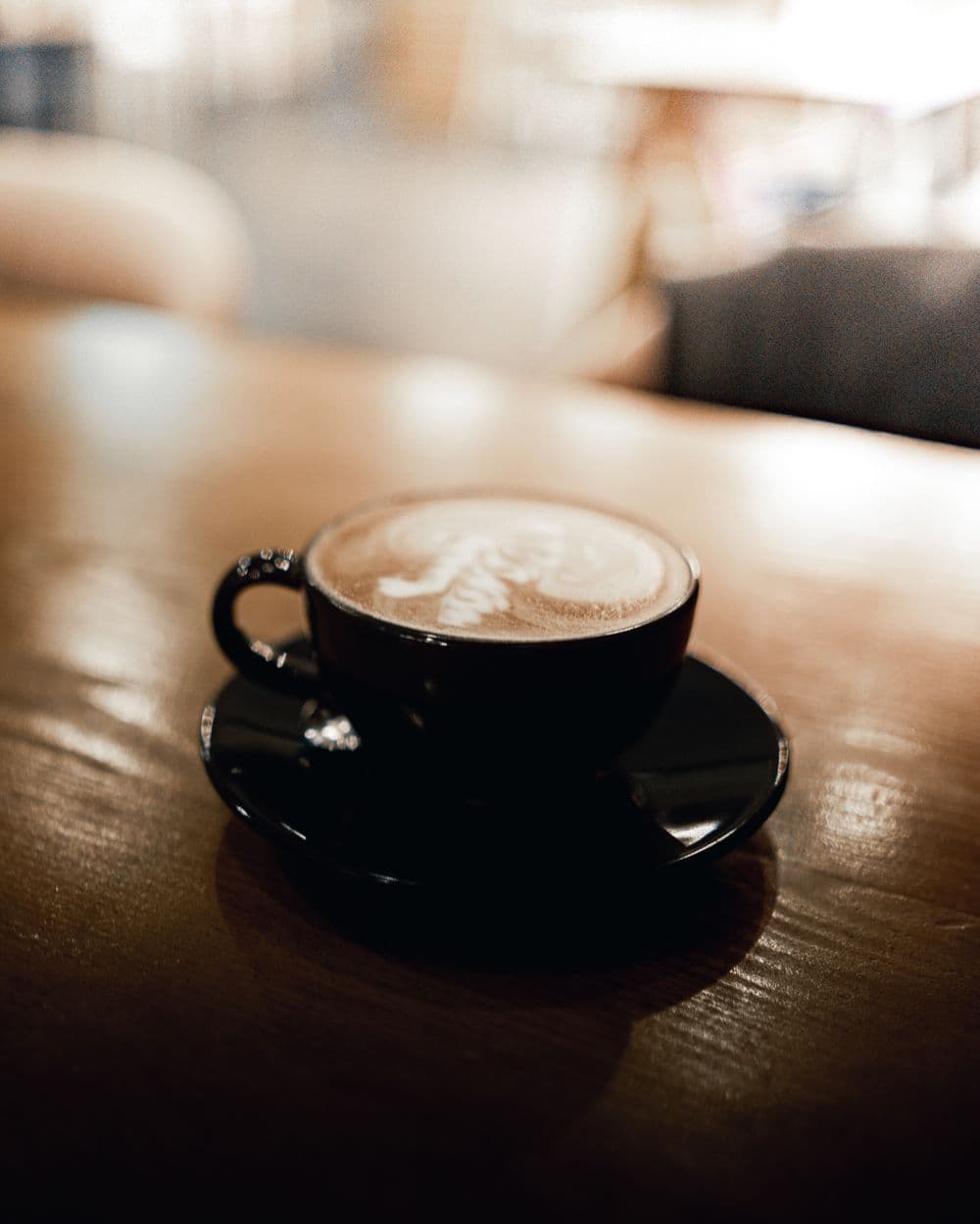 Cappuccino in a black cup with latte art